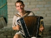 happy button accordion player against old wall evening outdoor